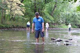 Volunteers learn how to look for mussels in a creek during a mussel monitoring workshop. 